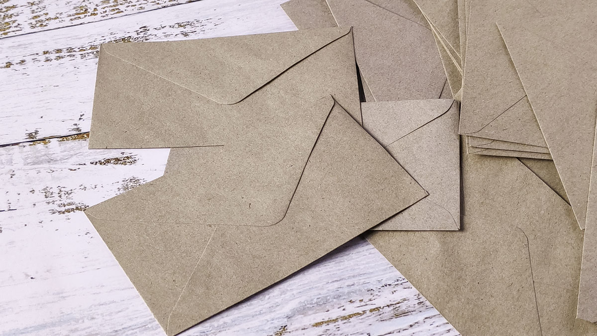 Sobres de papel kraft apoyados sobre un escritorio de madera